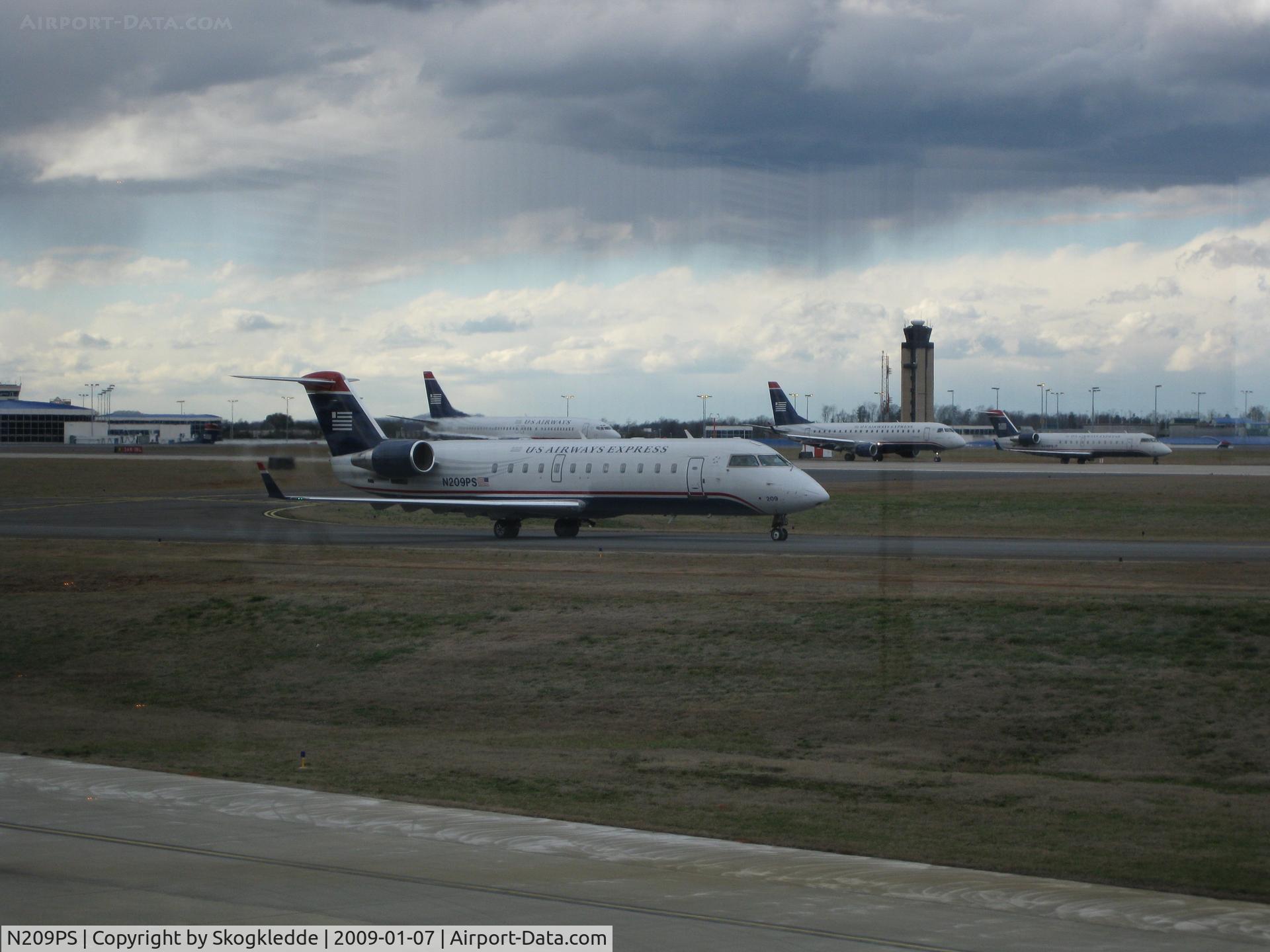 N209PS, 2003 Bombardier CRJ-200ER (CL-600-2B19) C/N 7874, Papa Sierra in line with a lot of her sister aircraft on a windy day at CLT.