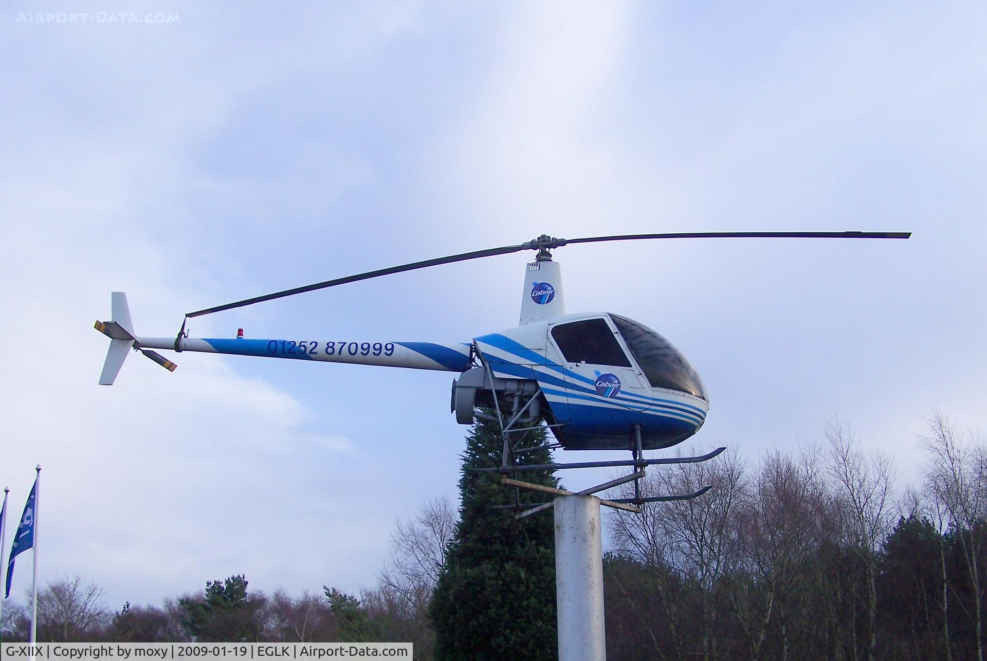 G-XIIX, 1988 Robinson R22 Beta C/N 0736, R22 on Pole at entrance to Blackbushe
