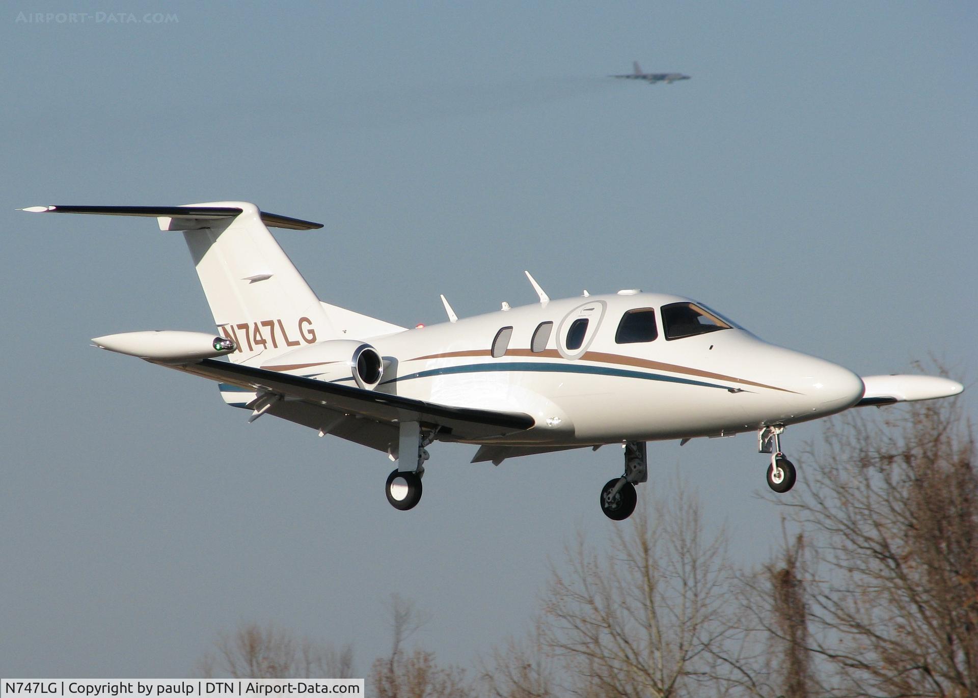 N747LG, 2008 Eclipse Aviation Corp EA500 C/N 000235, Landing at the Downtown Shreveport with a B52H from Barksdale Air Force Base shadowing in the background.