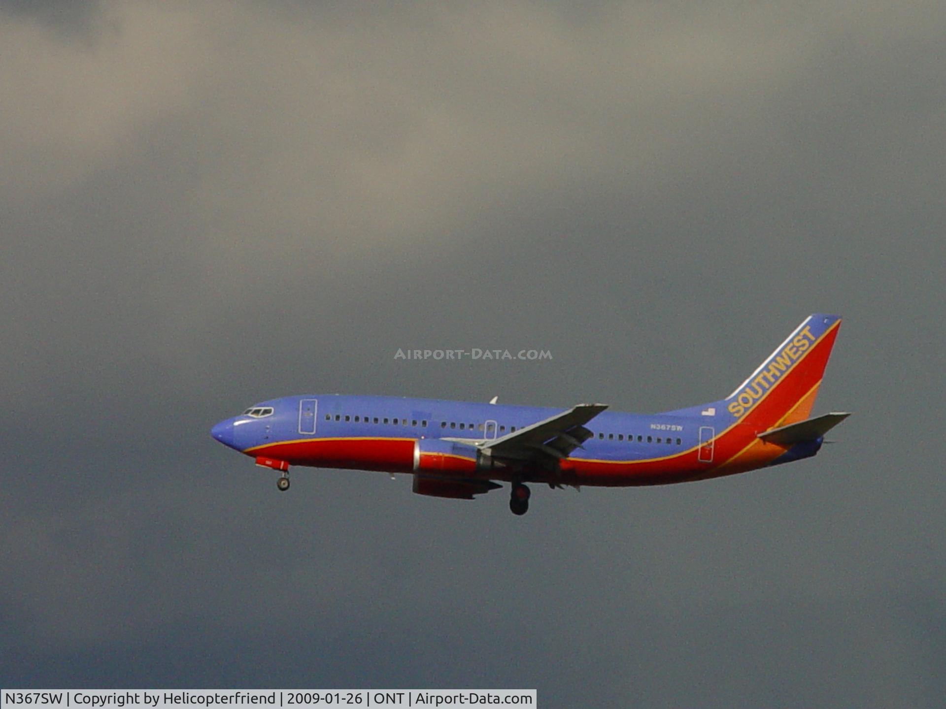 N367SW, 1993 Boeing 737-3H4 C/N 26578, Approaching outer fence under dark clouds at Ontario