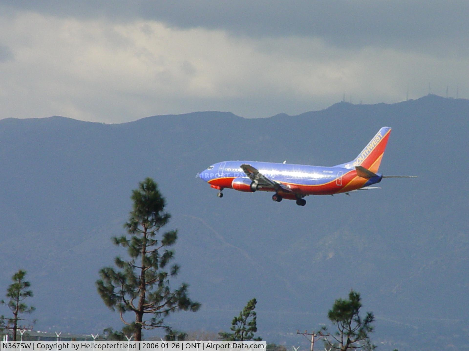 N367SW, 1993 Boeing 737-3H4 C/N 26578, Passing over the outer fence and trees at Ontario