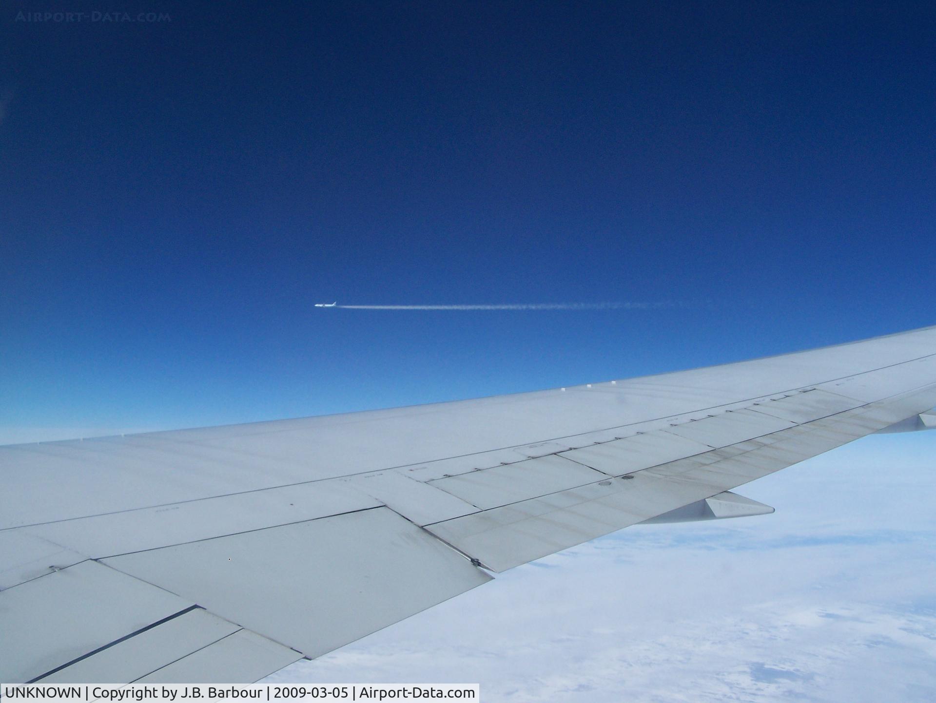 UNKNOWN, Contrails Various C/N Unknown, Onboard a B767, flying somewhere between Iceland and Canada.  This aircraft was about a mile away and flew right over us about 1000 ft.  It was awsome watching the contrails vaporate as it went by.