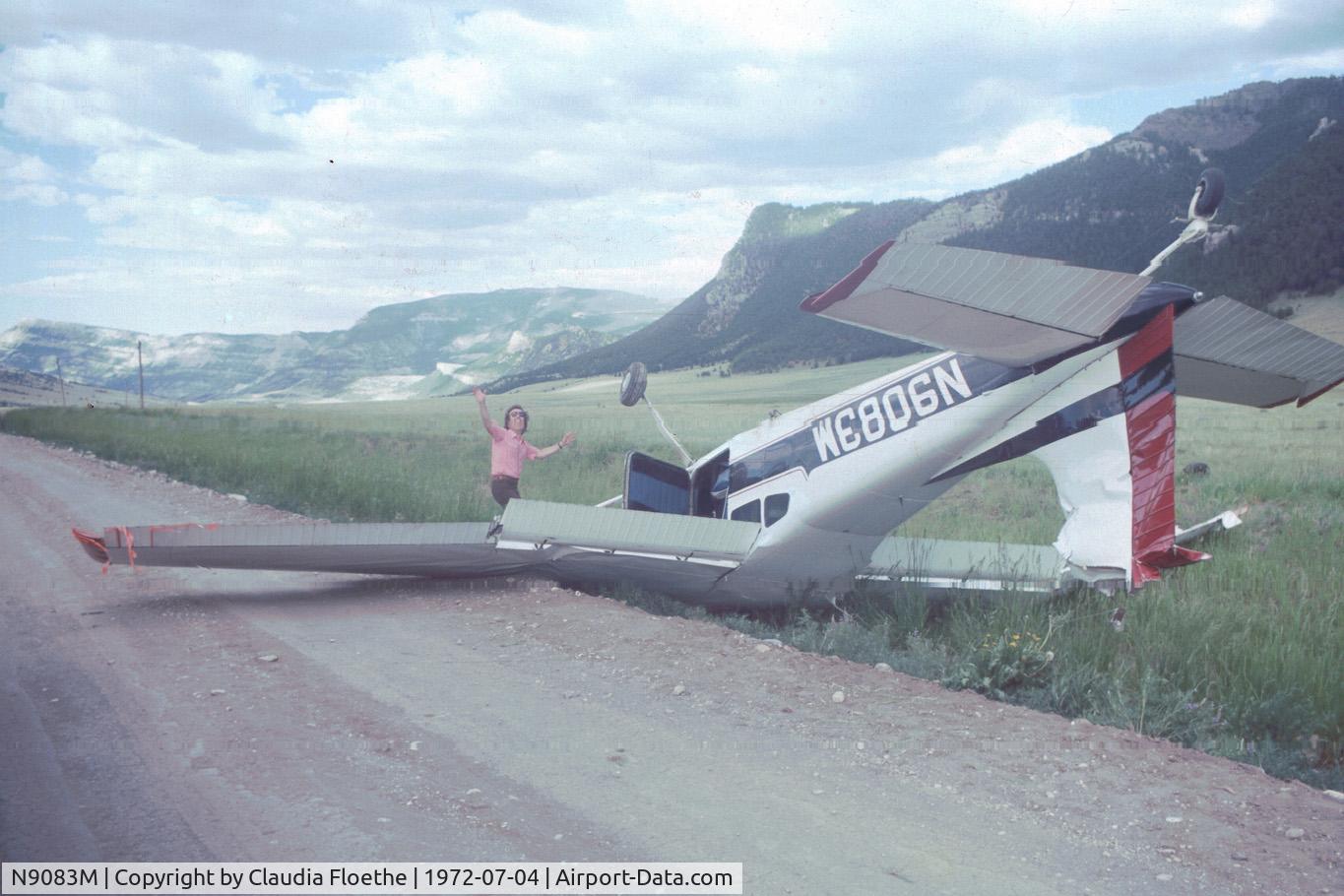 N9083M, 1971 Cessna 180H Skywagon C/N 18052183, Wrecked plane found abandoned and upside down on a road outside Cody, WY in 1972. The plane apparently clipped some power lines while landing. The pilot was unhurt. The person, just clowning around in the picture, is Stephen Floethe. The aircraft apparent