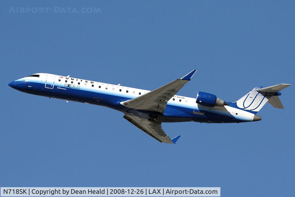 N718SK, 2004 Bombardier CRJ-701 (CL-600-2C10) Regional Jet C/N 10184, United Express (SkyWest Airlines) N718SK (FLT SKW6852) climbing out from RWY 25R enroute to Aspen/Pitkin County Airport (KASE).