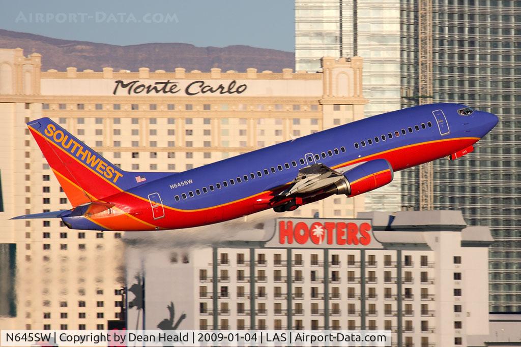 N645SW, 1997 Boeing 737-3H4 C/N 28330, Southwest Airlines N645SW (FLT SWA1523) climbing out from RWY 1R, with a nice casino backdrop with early morning light, enroute to Ontario Int'l (KONT).