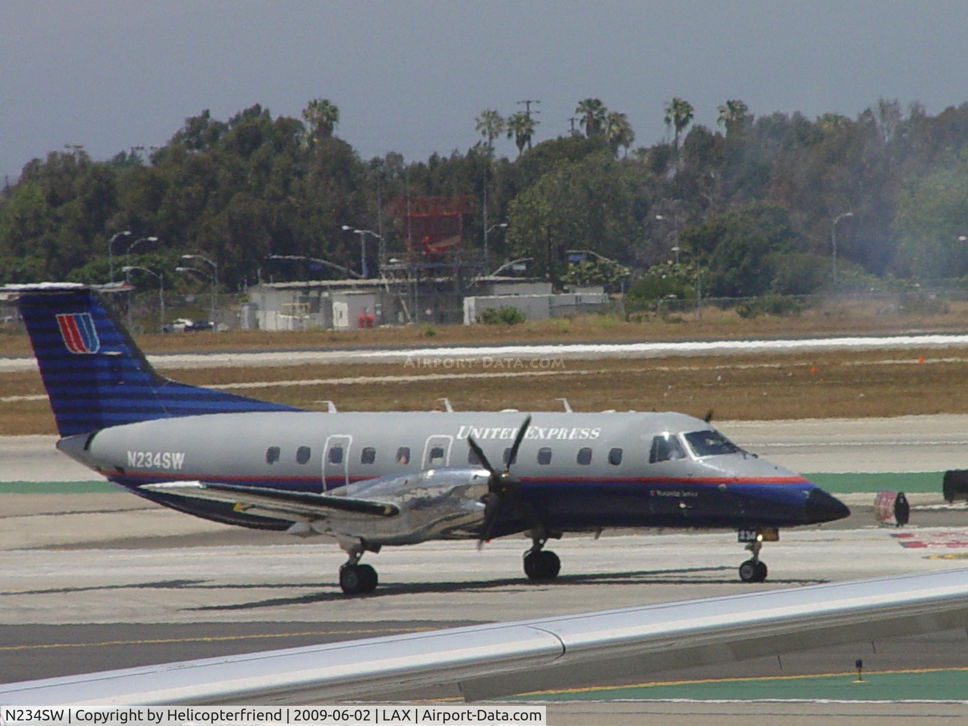 N234SW, 1996 Embraer EMB-120ER Brasilia C/N 120.308, Waiting to enter Runway 24L, smoke is from landing aircraft on 24R