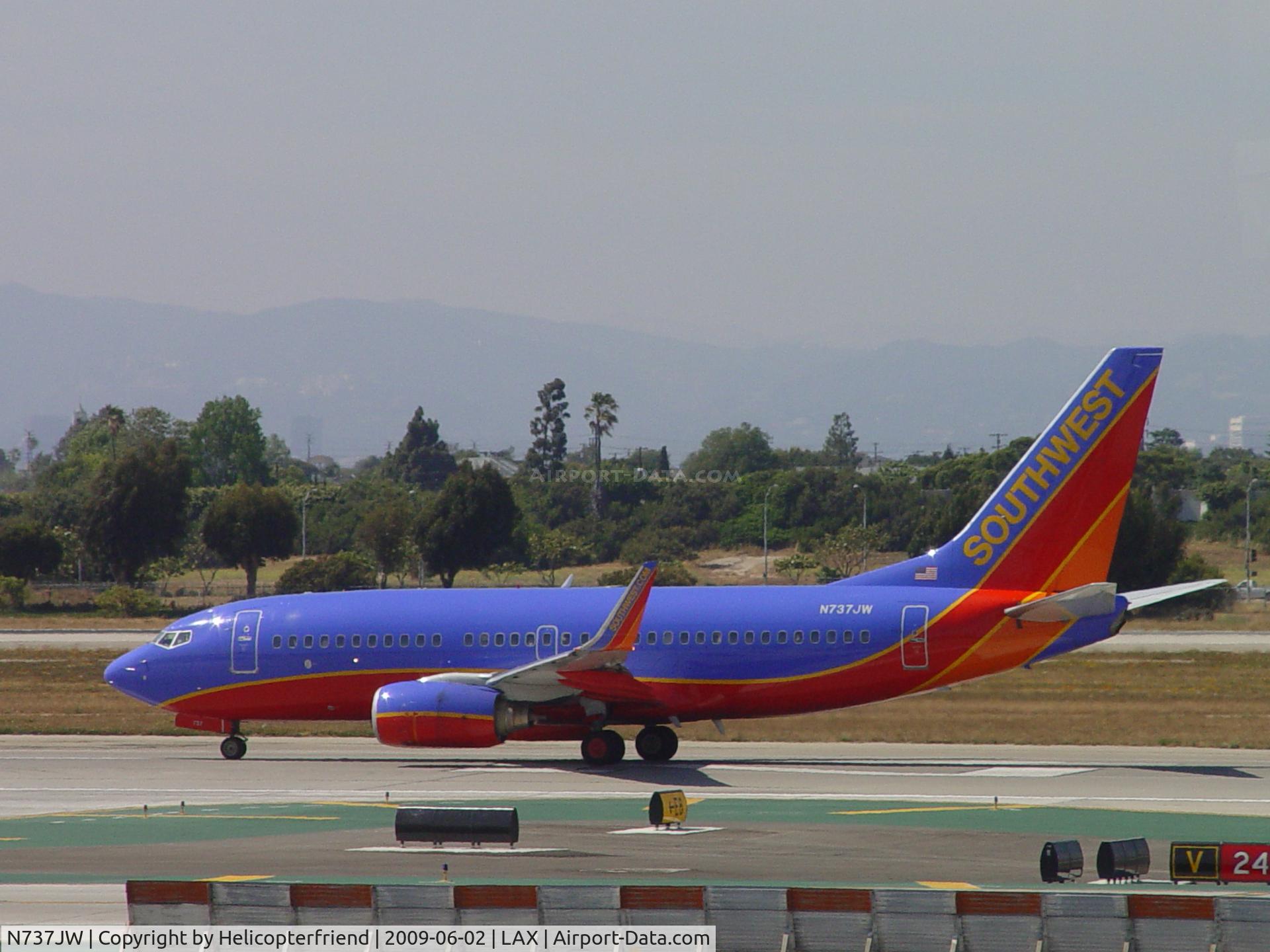 N737JW, 1999 Boeing 737-7H4 C/N 27869, Taking off westbound on 24L