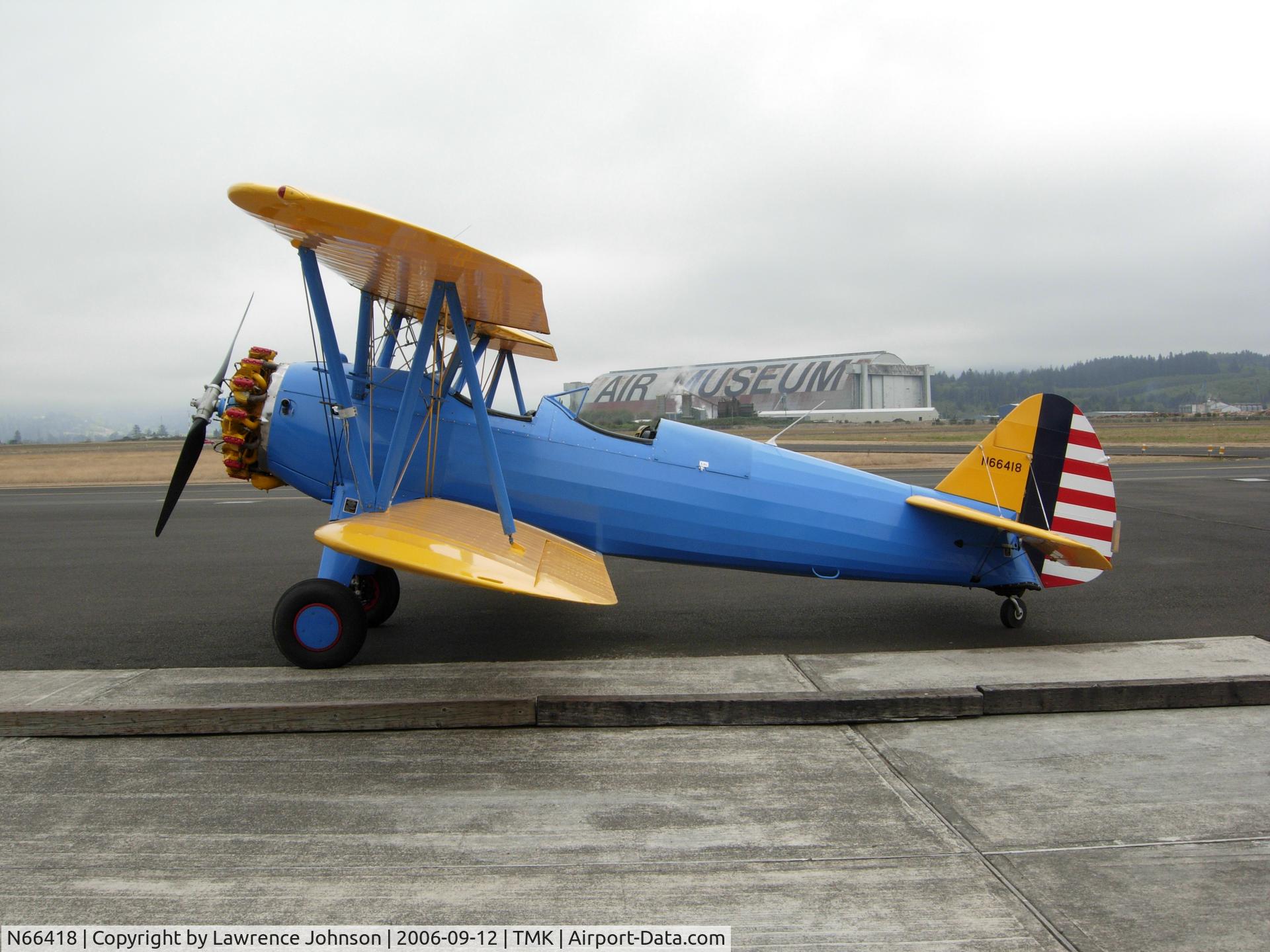 N66418, Boeing B75N1 C/N 75-6883, A west coast visitor. An old wooden blimp hanger is in the background.