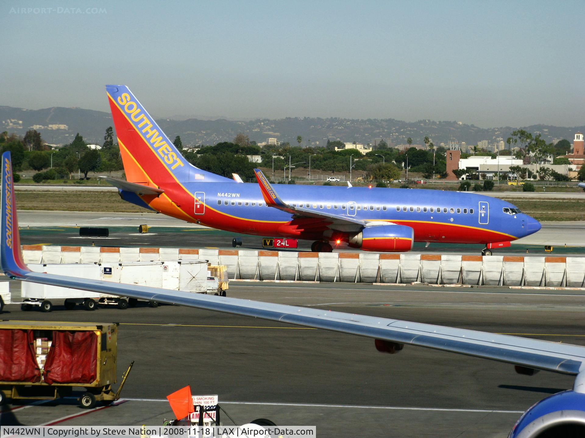 N442WN, 2003 Boeing 737-7H4 C/N 32459, Southwest 2003 Boeing 737-7H4 in new colors w/winglets framed by gate-mate