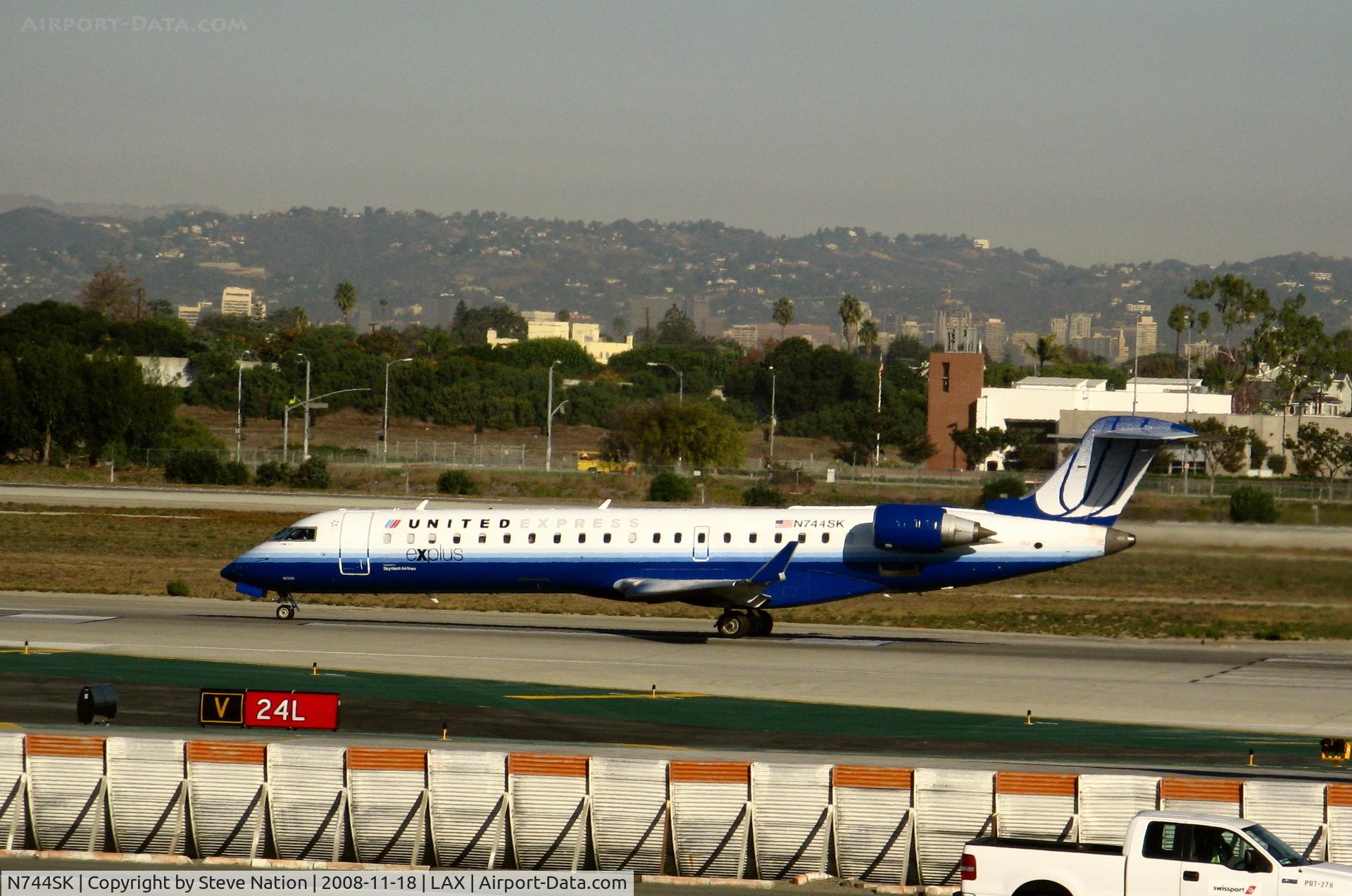 N744SK, 2005 Bombardier CRJ-701 (CL-600-2C10) Regional Jet C/N 10200, United Express 'Explus' 2005 Bombardier CL-600-2C10 in latest colors rolling on RW 24L