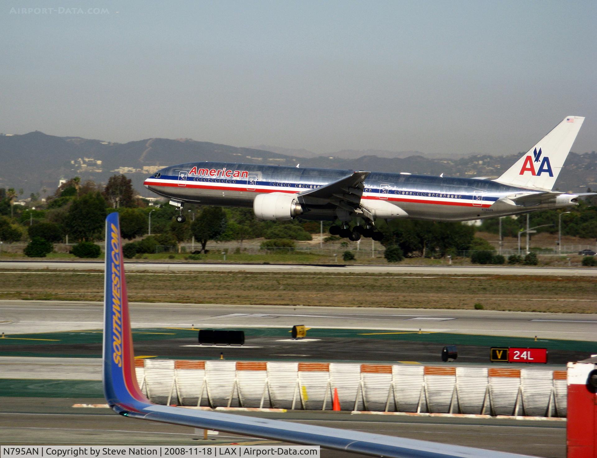 N795AN, 2000 Boeing 777-223 C/N 30257, American 2000 777-223 framed by wing of Southwest 737 on approach to RW 24L