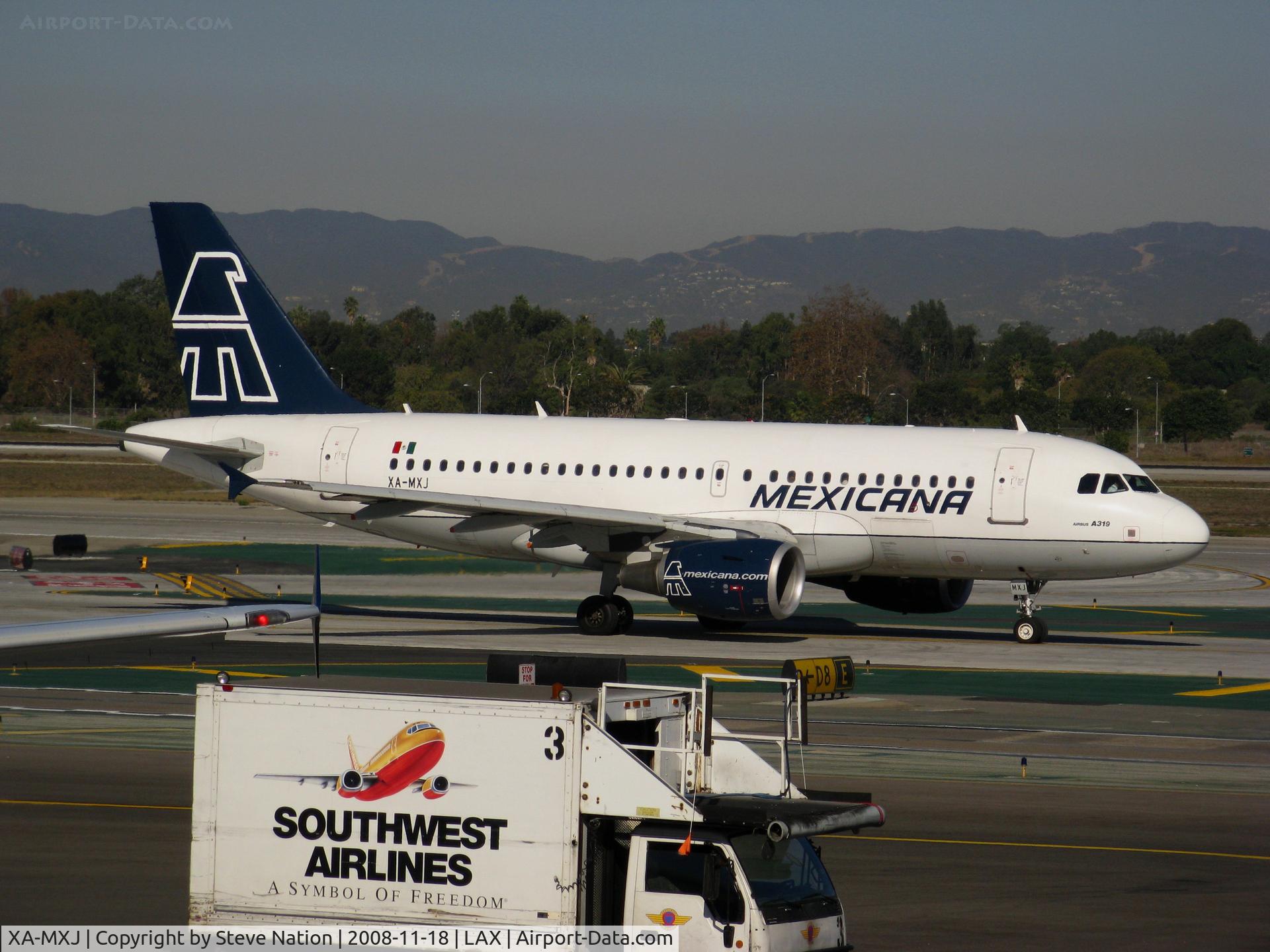 XA-MXJ, 2002 Airbus A319-112 C/N 1805, Mexicana Airbus A-319-112 racing Southwest Airlines food service truck