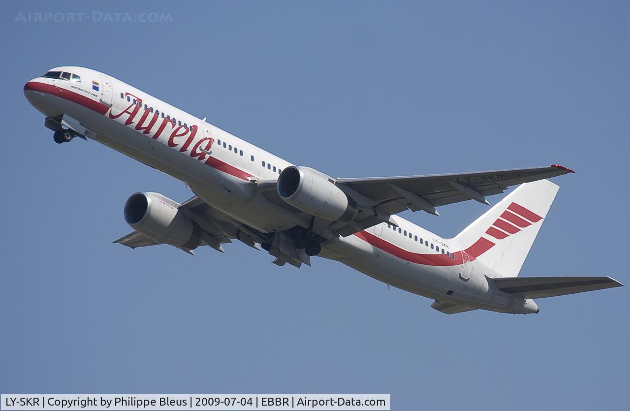 LY-SKR, 1999 Boeing 757-23N C/N 30233, Unusual visitor, climbing from rwy 25R, gear on the move.