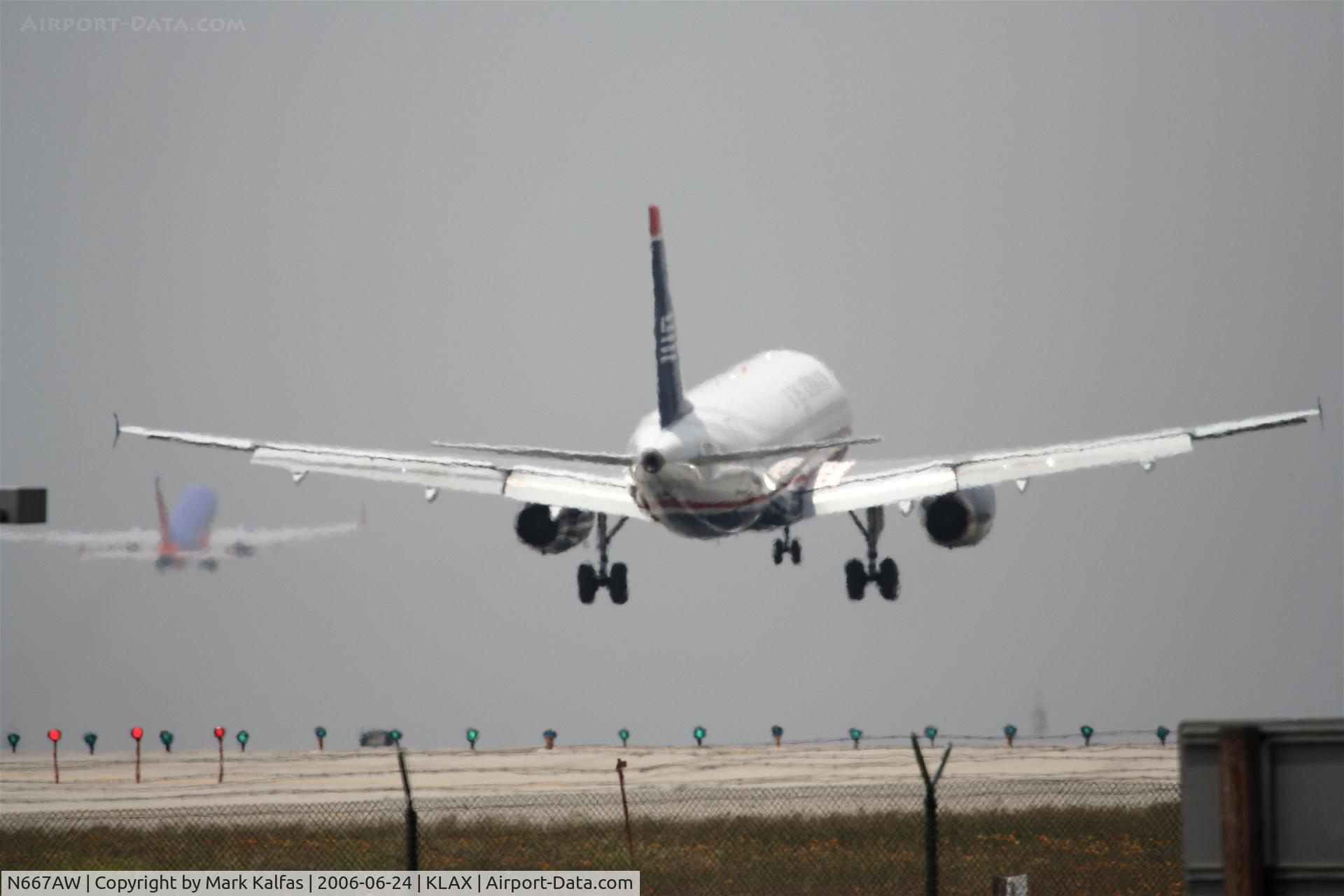 N667AW, 2002 Airbus A320-232 C/N 1710, US Airways Airbus A320-232, N667AW short final 24R KLAX, SouthWest 737 lifting off on 25L.