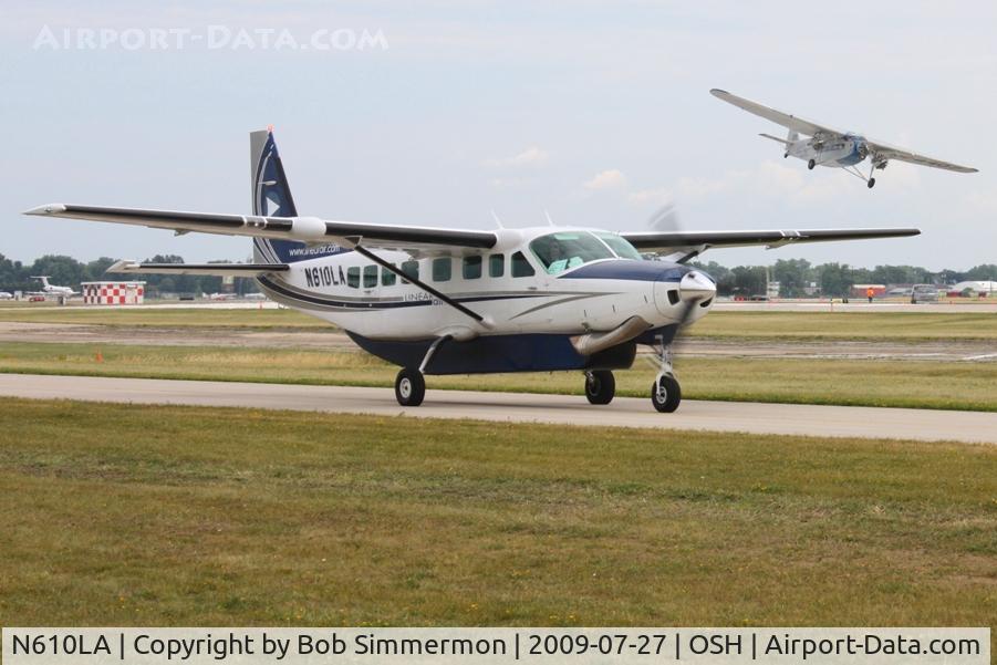 N610LA, 2004 Cessna 208B C/N 208B1060, Arriving at Airventure 2009 with N8407 landing in the background - Oshkosh, Wisconsin