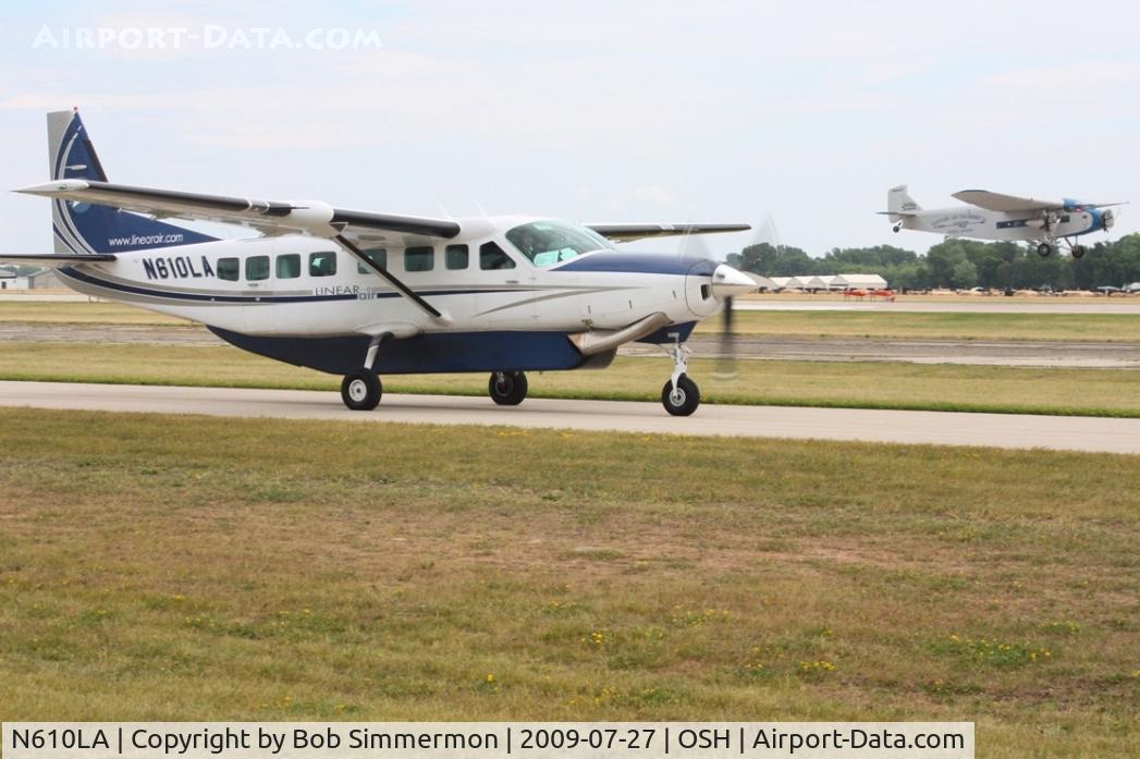 N610LA, 2004 Cessna 208B C/N 208B1060, Arriving at Airventure 2009 with N8407 landing in the background - Oshkosh, Wisconsin