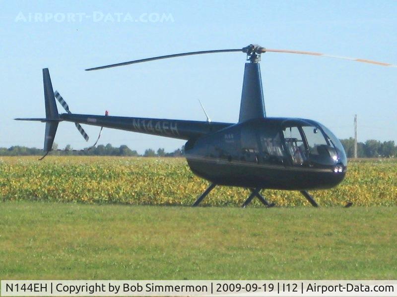 N144EH, 2005 Robinson R44 II C/N 10742, Parked in the grass at Sidney, Ohio during the EAA fly-in.