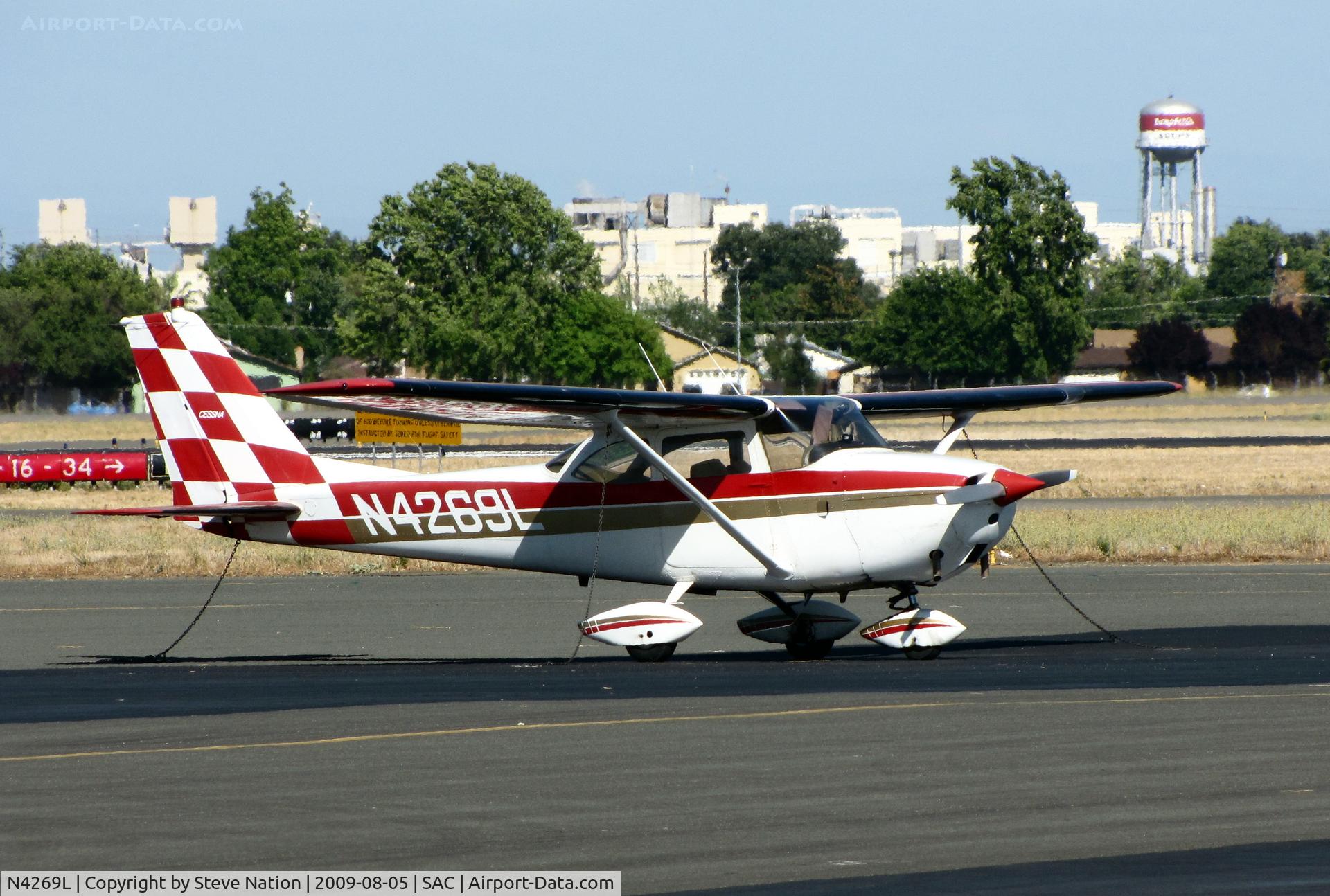 N4269L, 1966 Cessna 172G C/N 17254338, Red & white checkered tail 1966 Cessna 172G visiting from CCR (Concord, CA) with Campbell's Soup factory water tank in background