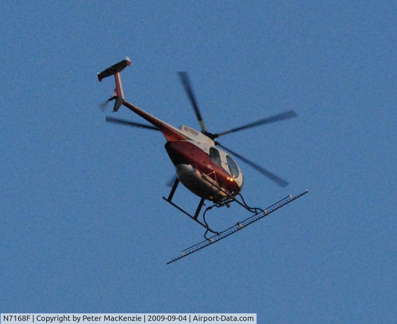 N7168F, 1977 Hughes 369D C/N 570131D, in flight with sprayer attachment