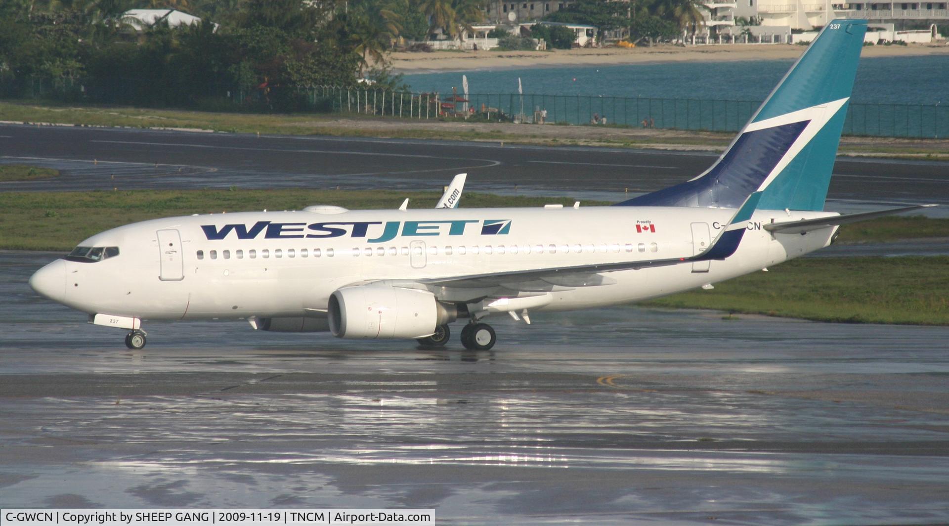 C-GWCN, 2005 Boeing 737-7CT C/N 34157, West jet taxing to parking on a wet tarmac. after some rain showers