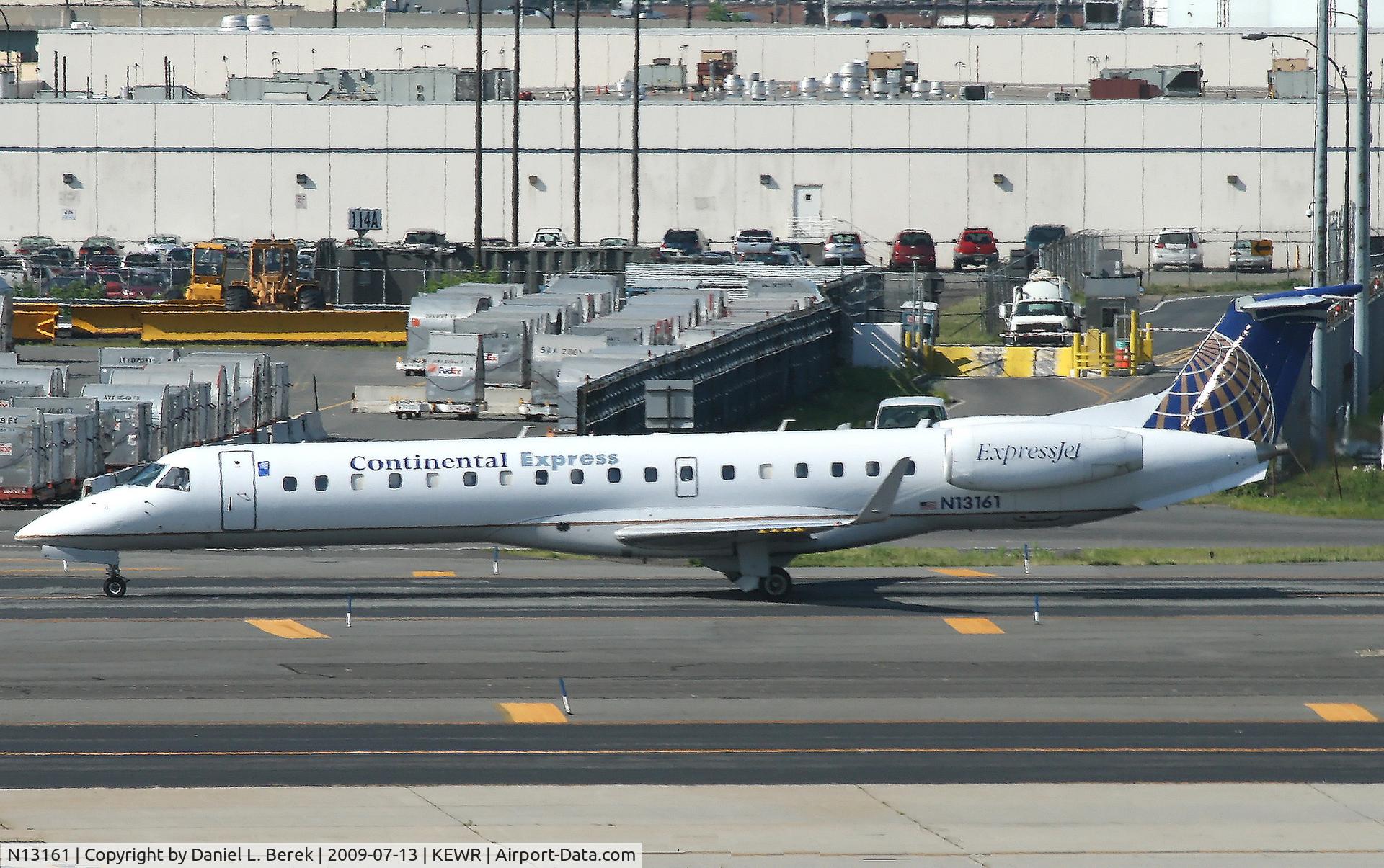 N13161, 2004 Embraer ERJ-145XR (EMB-145XR) C/N 14500805, Yet another CO ExpressJet taxies past cargo containers at Newark Airport.