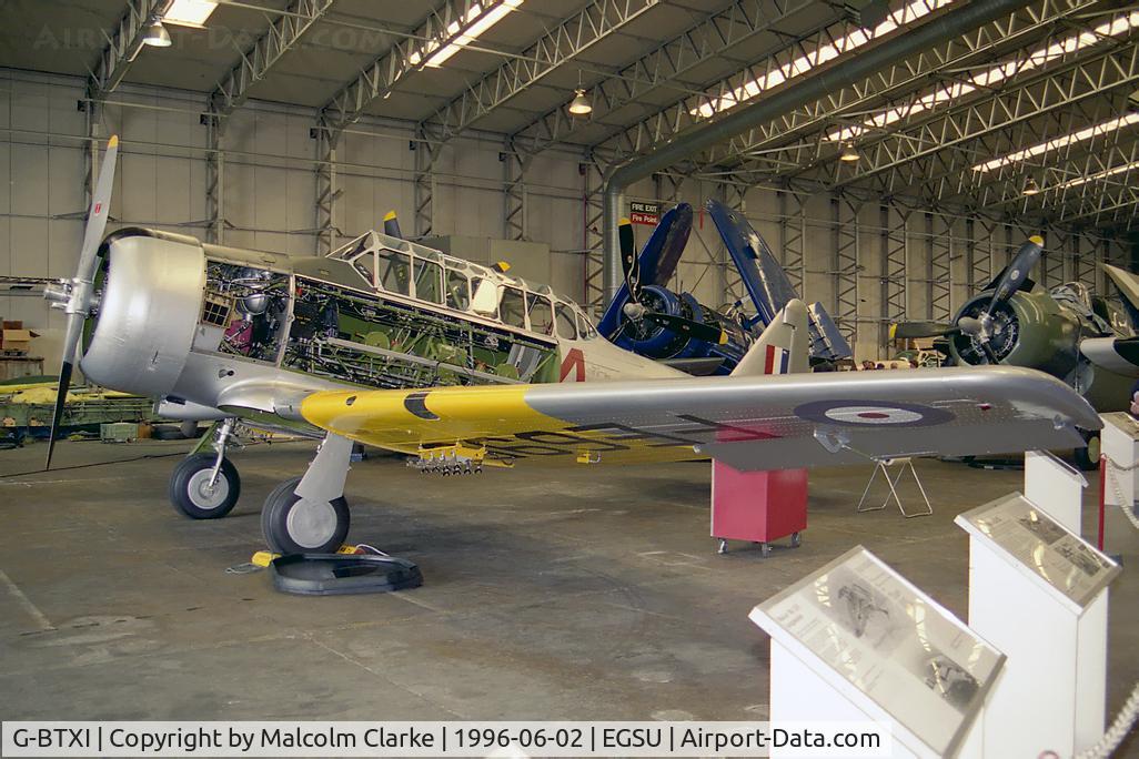 G-BTXI, 1942 Noorduyn AT-16 Harvard IIB C/N 14-429, Noorduyn AT-16 Harvard Mk2B. As FE695 of the Royal Air Force, undergoing maintenance in the 'active' hangar at the Imperial War Museum, Duxford in 1996.