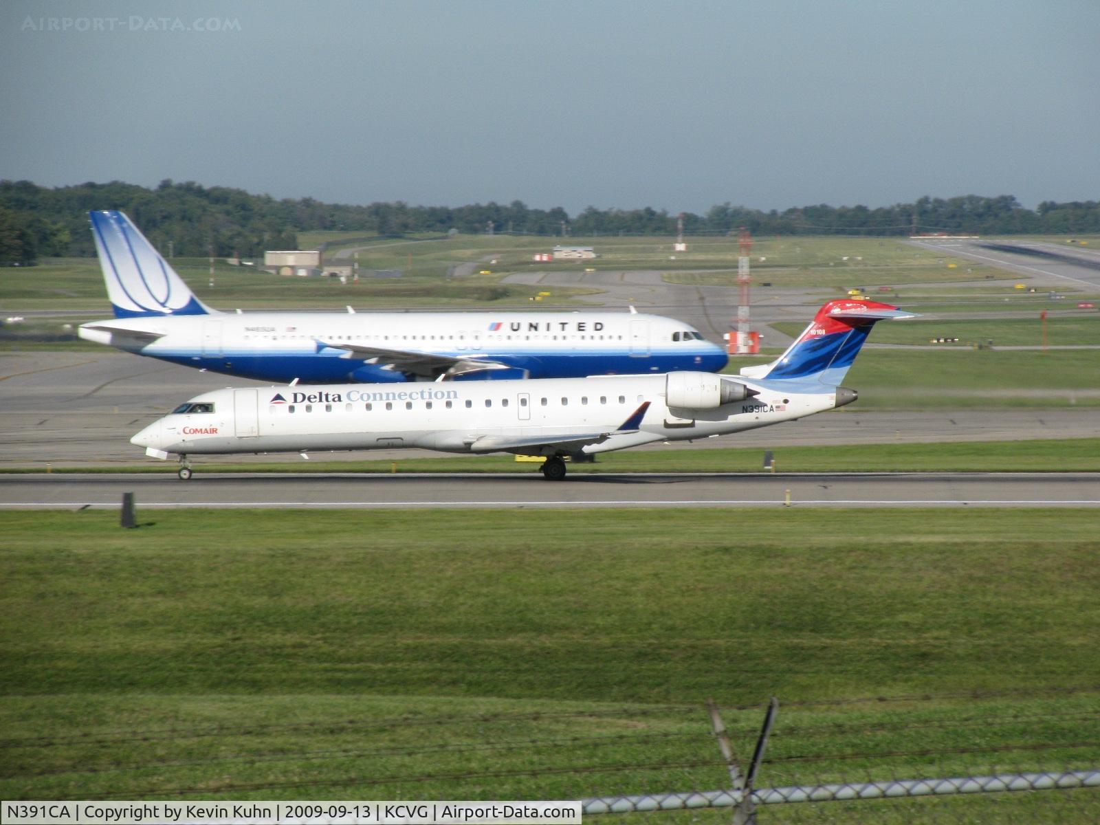 N391CA, 2003 Bombardier CRJ-701ER (CL-600-2C10) Regional Jet C/N 10108, Passing by a rare non-Delta visitor (N465UA) on her takeoff roll