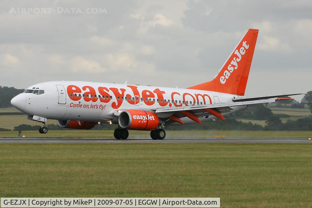 G-EZJX, 2003 Boeing 737-73V C/N 32419, Touching down as a brisk shower passes through.