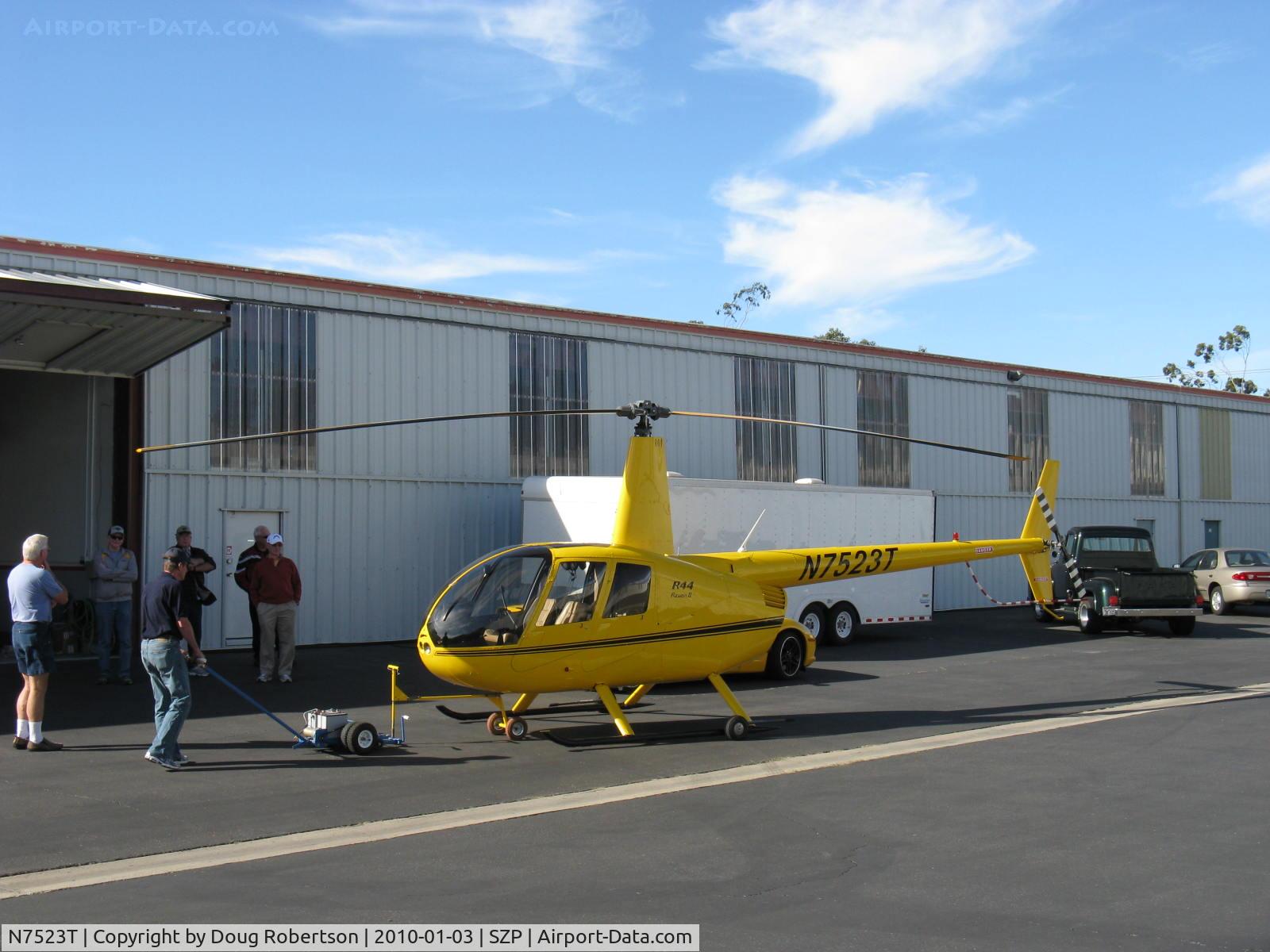 N7523T, 2004 Robinson R44 Raven II C/N 10311, 2004 Robinson R-44 RAVEN II, Lycoming IO-540 derated to 245 Hp for 5 minutes, 205 Hp continuous, respotting to get Turbine Legend N724RX out of hangar to fly.