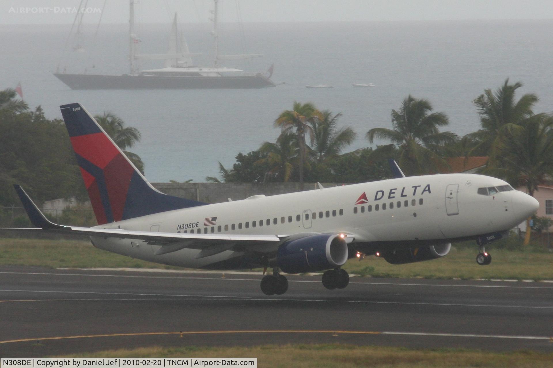 N308DE, 2009 Boeing 737-732 C/N 29656, Delta airlines departing TNCM runway 28 on a wet day