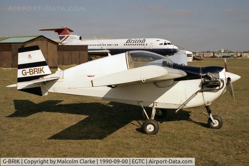 G-BRIK, 1977 Tipsy T-66 Nipper 3 C/N PFA 025-10174, Tipsy T-66 Nipper 3 at Cranfield Airport in 1989. In the background is ex British Airways Trident 3B G-AWZN, utilised by Cranfield University for 'bruising' passenger evacuation trials in the early 90's and dismantled in 1995.