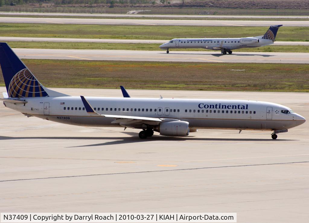 N37409, 2001 Boeing 737-924 C/N 30126, A COA B739 taxis next to a departing company ERJ.