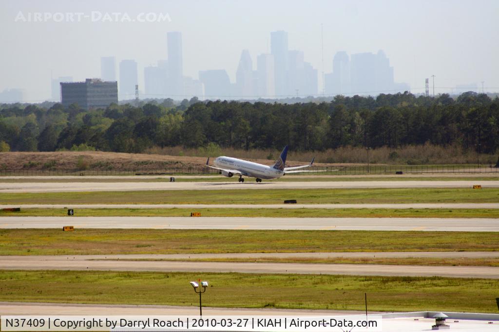 N37409, 2001 Boeing 737-924 C/N 30126, B739 rotates on 15R with downtown as a backdrop.