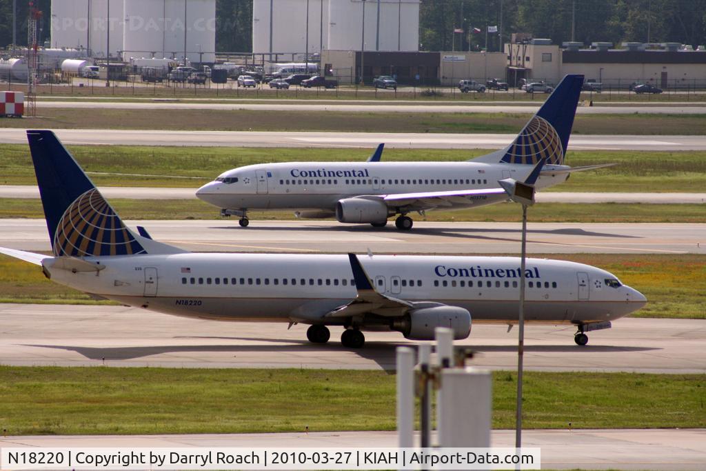 N18220, 1998 Boeing 737-824 C/N 28929, B738 gets closer to the departure runway in a long line as a company departs behind.