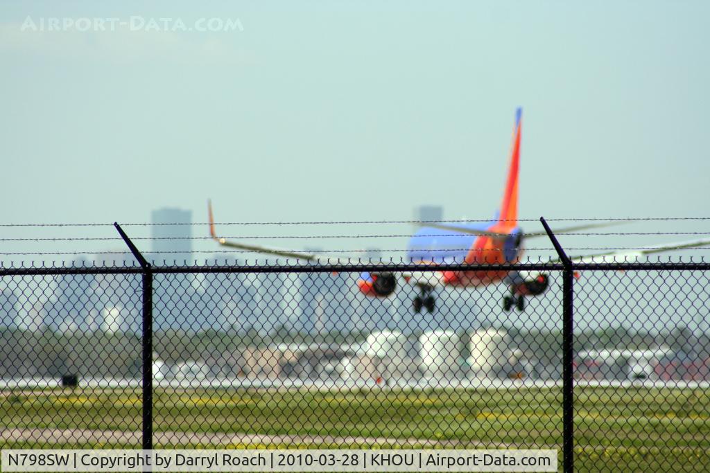 N798SW, 1998 Boeing 737-7AD C/N 28436, B737 touches down on 30L with downtown in front of him.