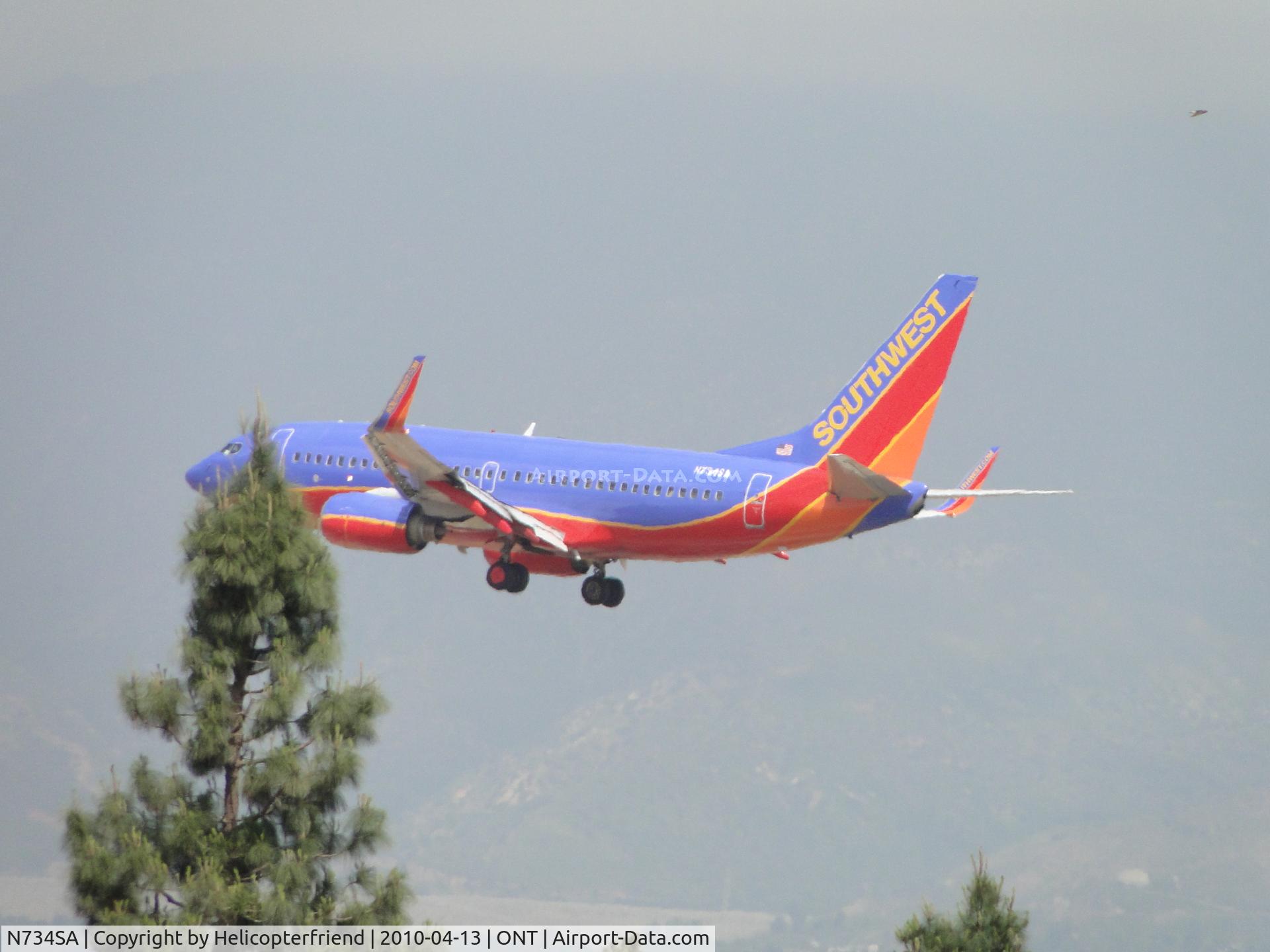 N734SA, 1999 Boeing 737-7H4 C/N 27866, Just over the trees and onto runway 26R