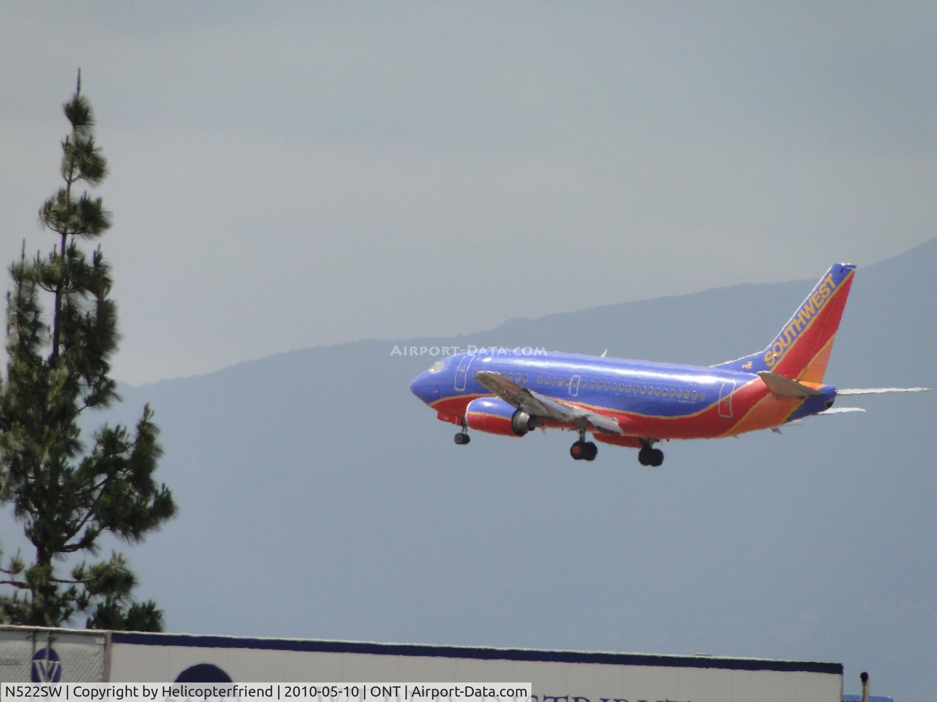 N522SW, 1992 Boeing 737-5H4 C/N 26564, Over trucks and trees from Sacramento to land on runway 26R