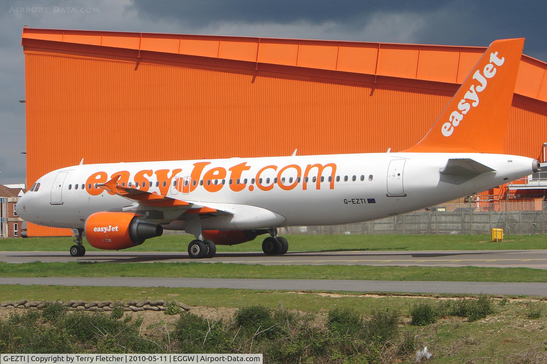 G-EZTI, 2009 Airbus A320-214 C/N 3975, Easyjet A320 taxies past base hangar