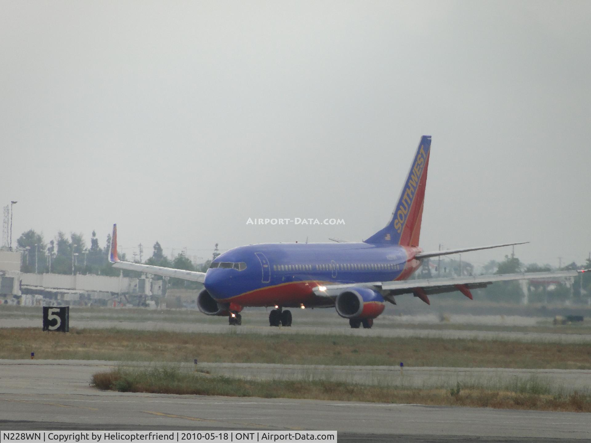 N228WN, 2005 Boeing 737-7H4 C/N 32496, Just landed runway 26L, engines still being reversed for braking