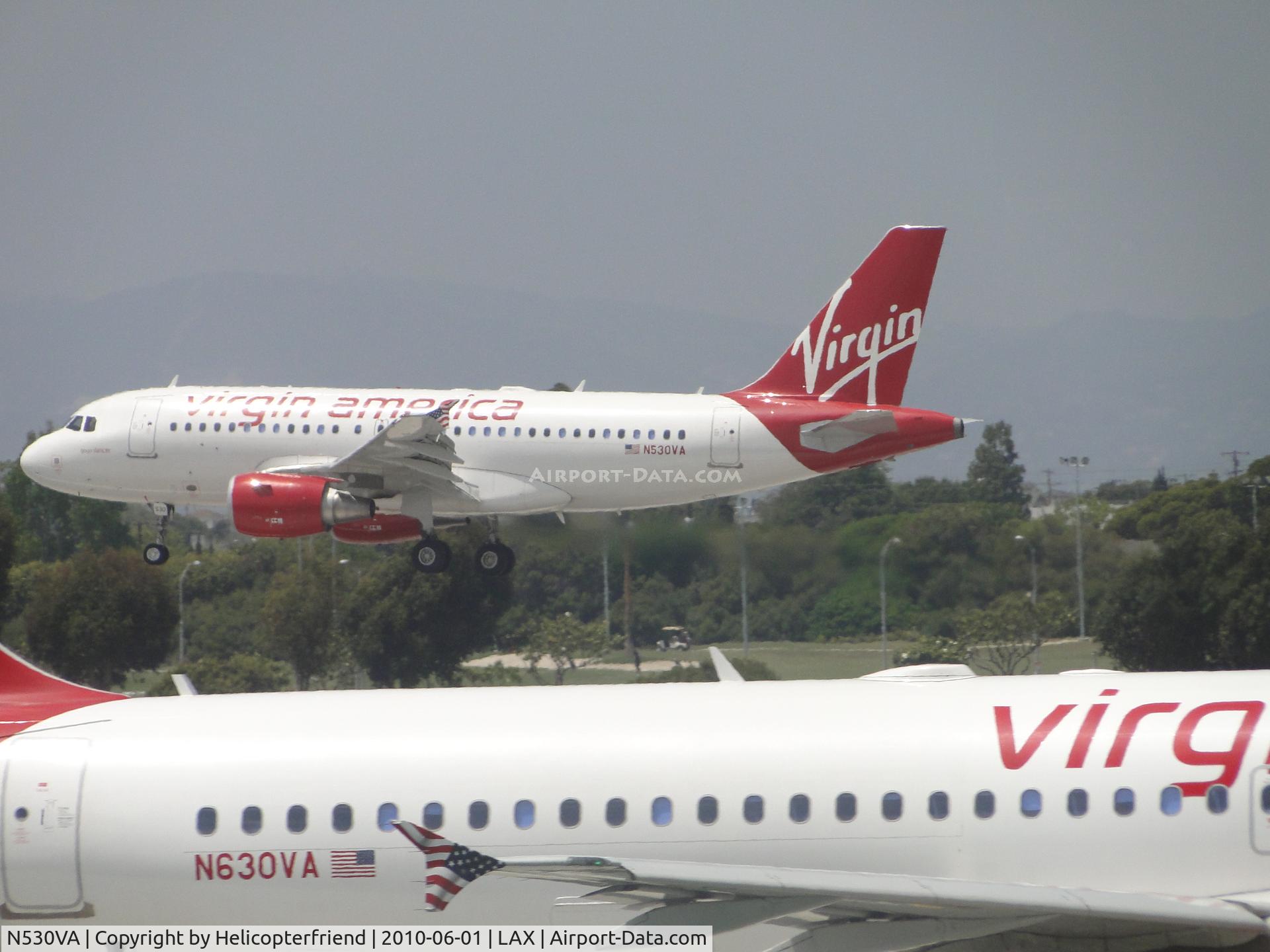 N530VA, 2008 Airbus A319-115 C/N 3686, N530VA landing on runway 24R while N630VA awaits to take off on runway 24L