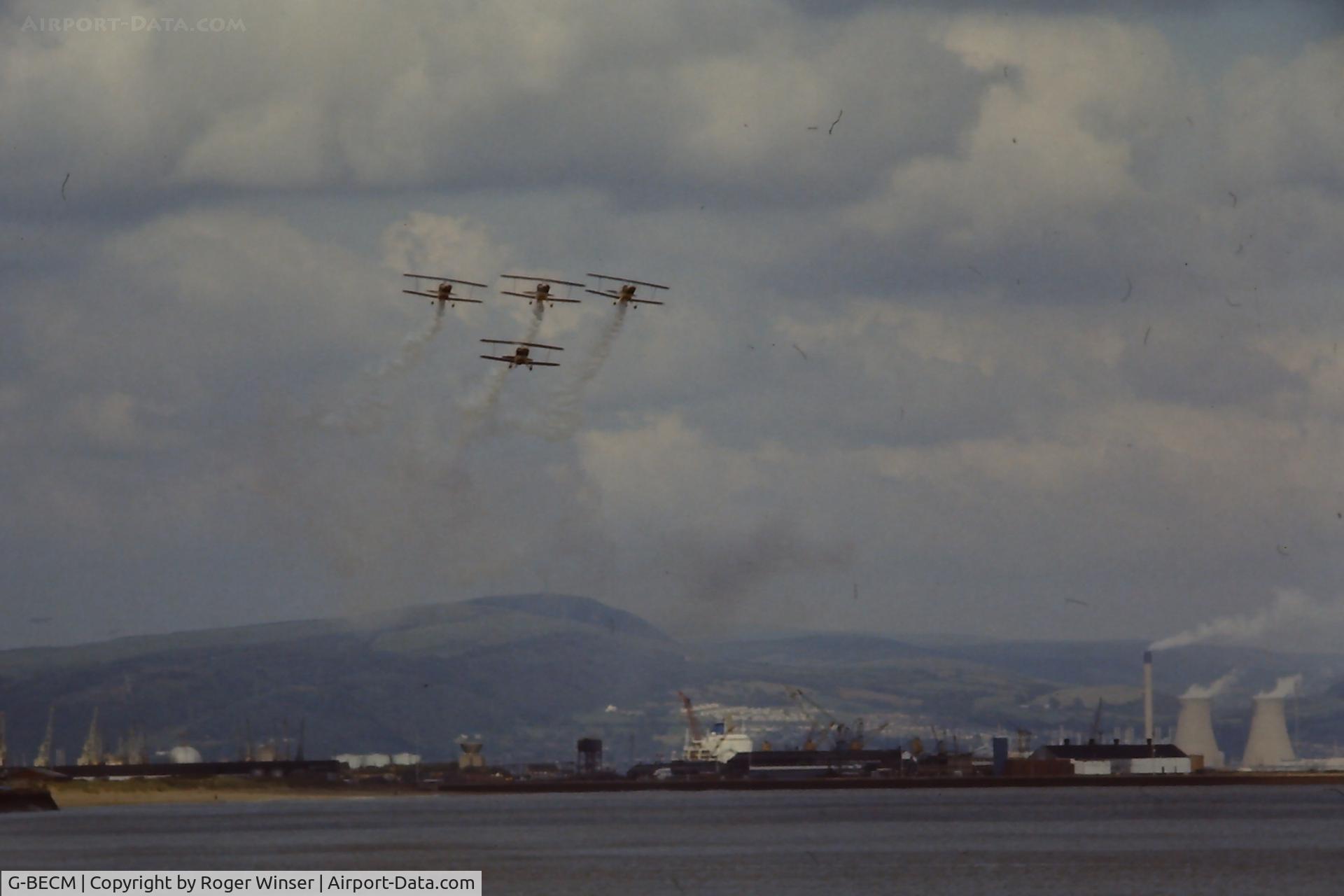 G-BECM, 1976 Aerotek Pitts S-2A Special C/N 2121, Off airport. Rothmans Aerobatic Team during an Air Show over Swansea Bay, Wales late 1970's/early 1980's. Also taking part are G-BADY, G-BADW and G-BDKS