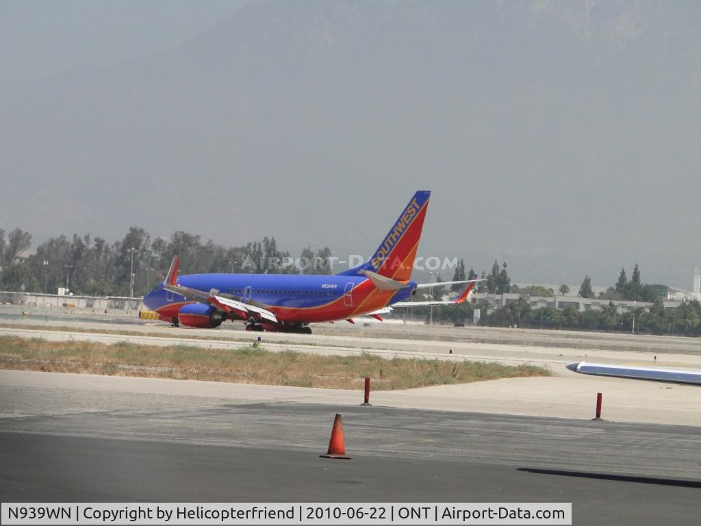 N939WN, 2009 Boeing 737-7H4 C/N 36646, Turning off runway 26L after Southwest N929WN took off on runway 26R