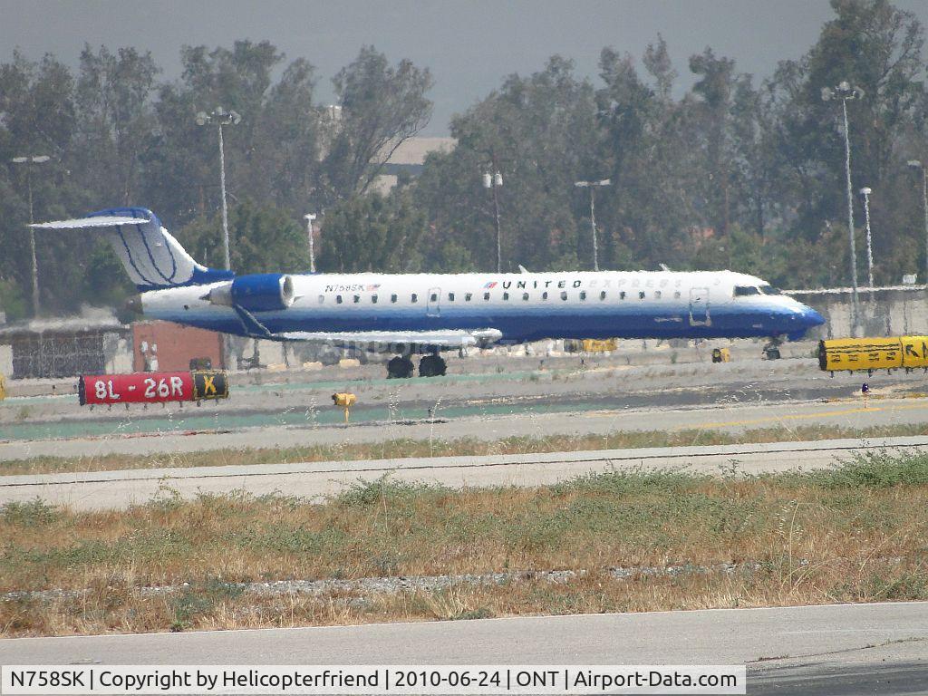N758SK, 2005 Bombardier CRJ-701ER (CL-600-2C10) Regional Jet C/N 10222, Just landed on 26R and exited active runway and is taxiing to terminal