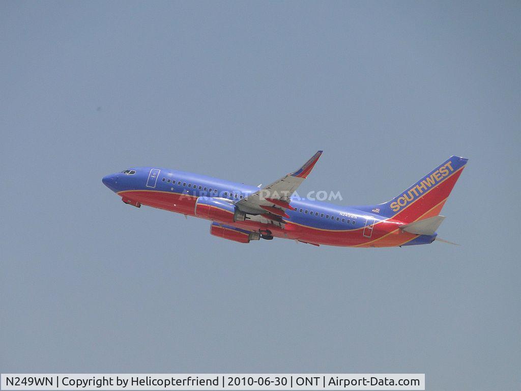 N249WN, 2006 Boeing 737-7H4 C/N 34951, Airbourne, wheels coming up, and headed westbound from 26R