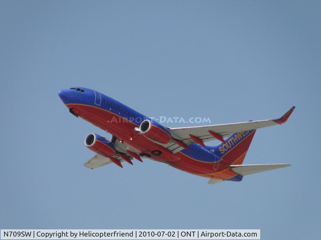 N709SW, 1998 Boeing 737-7H4 C/N 27843, After loading passengers, taking off westbound from runway 26R