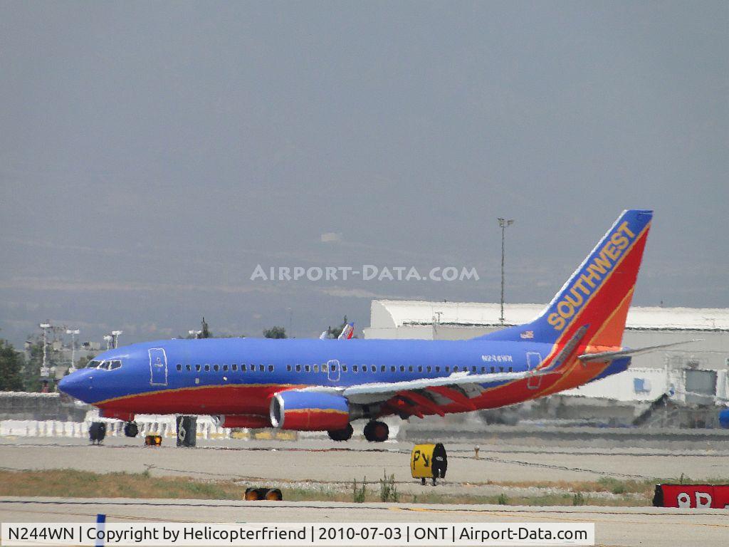 N244WN, 2006 Boeing 737-7H4 C/N 34864, Rolling out on runway 26L and turning northbound to taxi to terminal