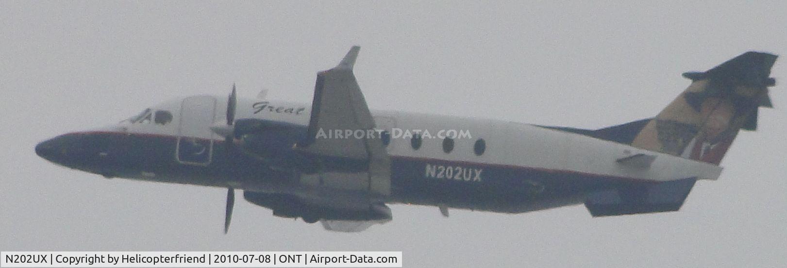 N202UX, 1996 Beech 1900D C/N UE-202, Heading westbound after lift off from runway 26R on a gloomy morning