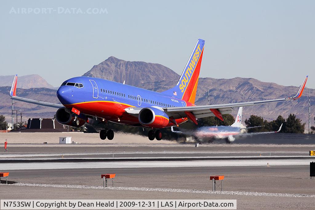 N753SW, 1999 Boeing 737-7H4 C/N 29848, Southwest Airlines N753SW (FLT SWA3690) from Phoenix Sky Harbor Int'l (KPHX) landing RWY 25L. An American 737 is in position for takeoff on RWY 25R.