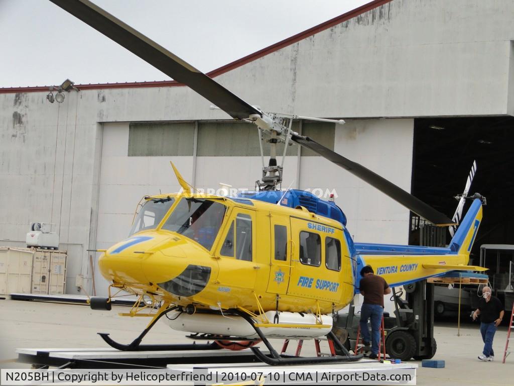 N205BH, 1969 Bell EH-1H Iroquois C/N 11373, Tail boom being held up by forklift while mechanics work on it