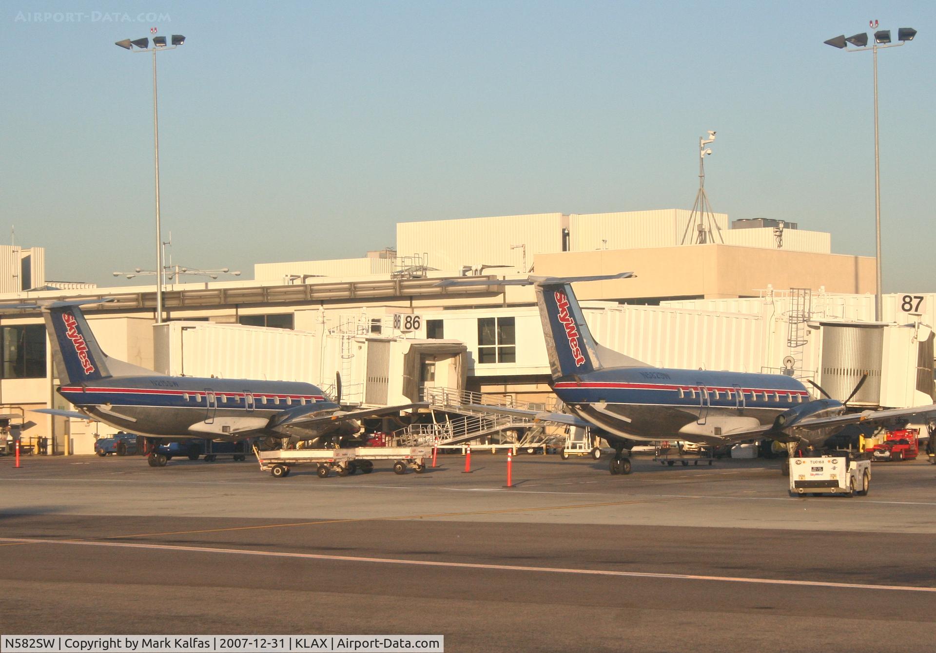 N582SW, 1999 Embraer EMB-120ER Brasilia C/N 120350, SkyWest Embraer EMB-120ER, N582SW (right) at gate 87 KLAX.